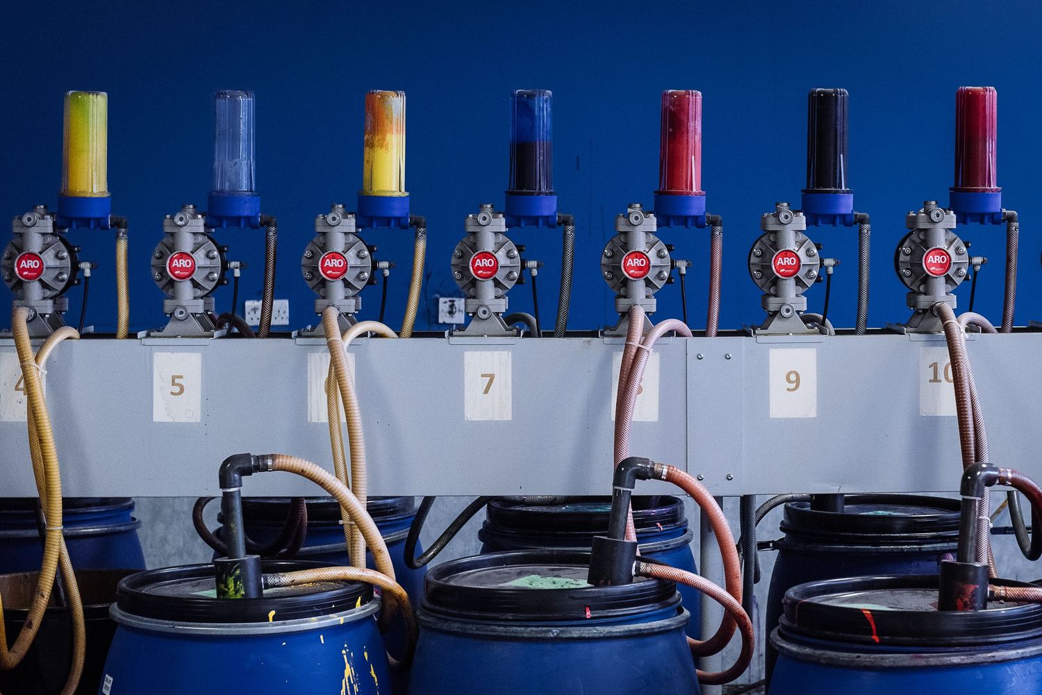 Industrial equipment with blue tanks and yellow pipes in a manufacturing facility.