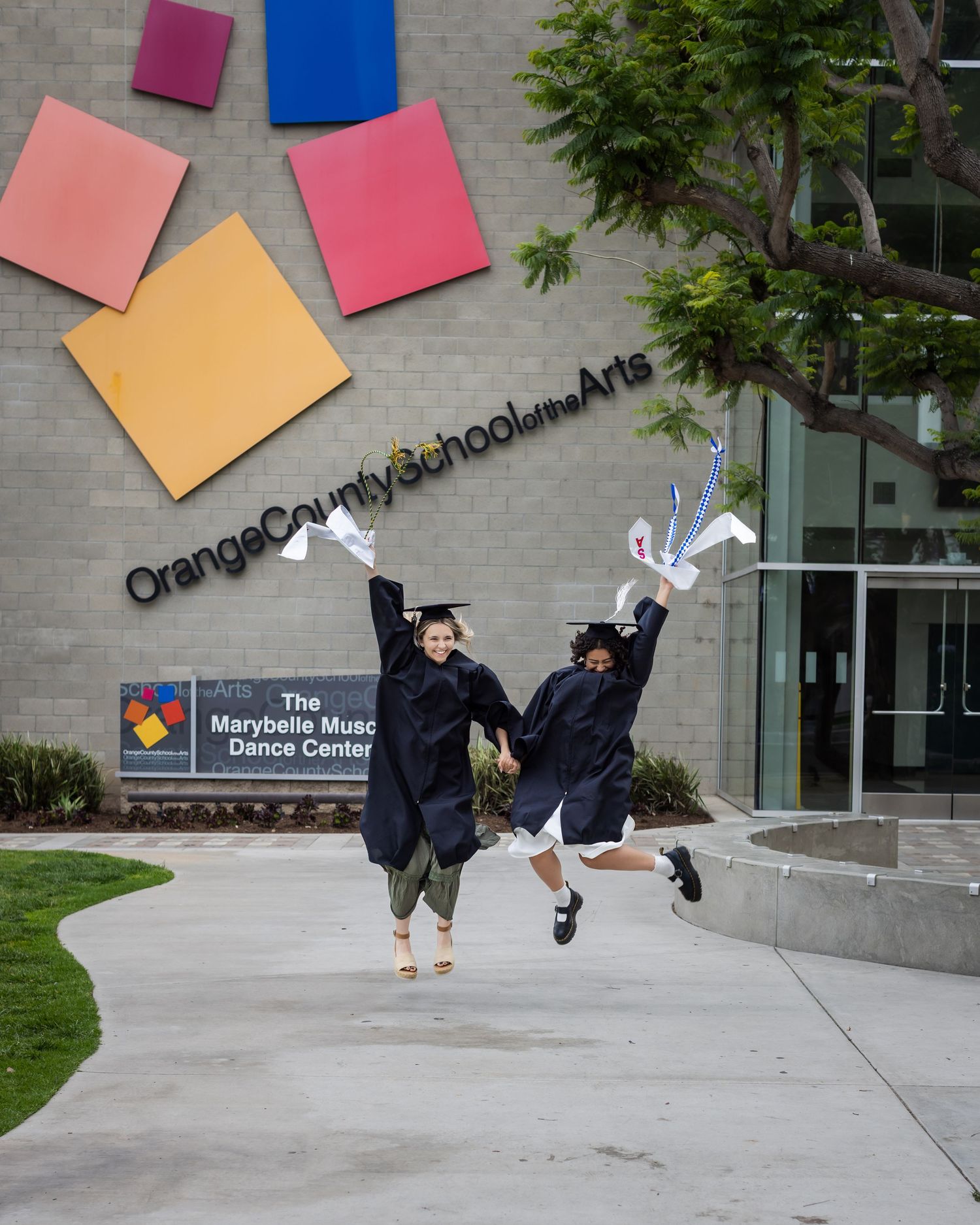 A series of four photos showing someone jumping in front of a brick building with colorful geometric shapes on the wall.