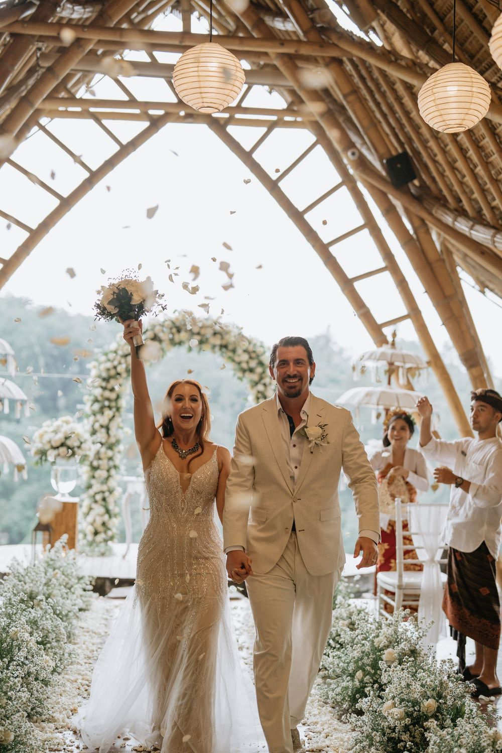 Wedding celebration in a rustic wooden venue decorated with paper lanterns and floral arrangements.