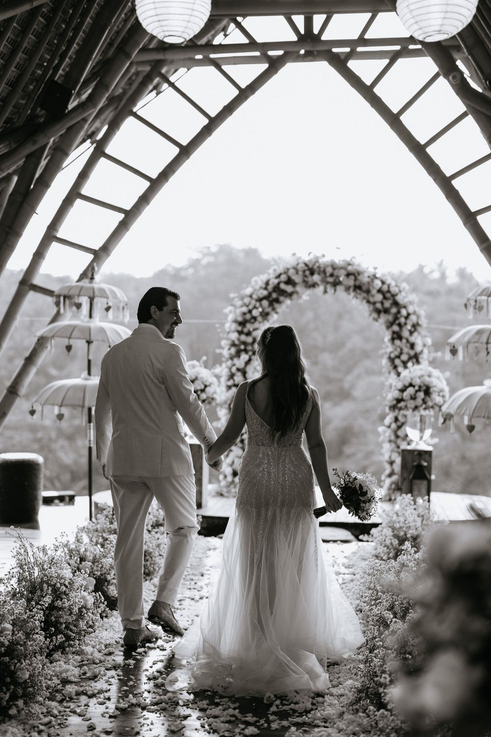 Black and white photo series of a couple dancing under paper lanterns at an outdoor wedding venue.