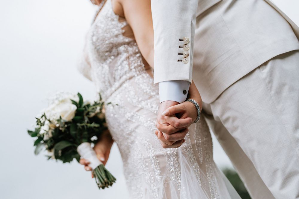 Close-up details of wedding attire in cream and white tones.