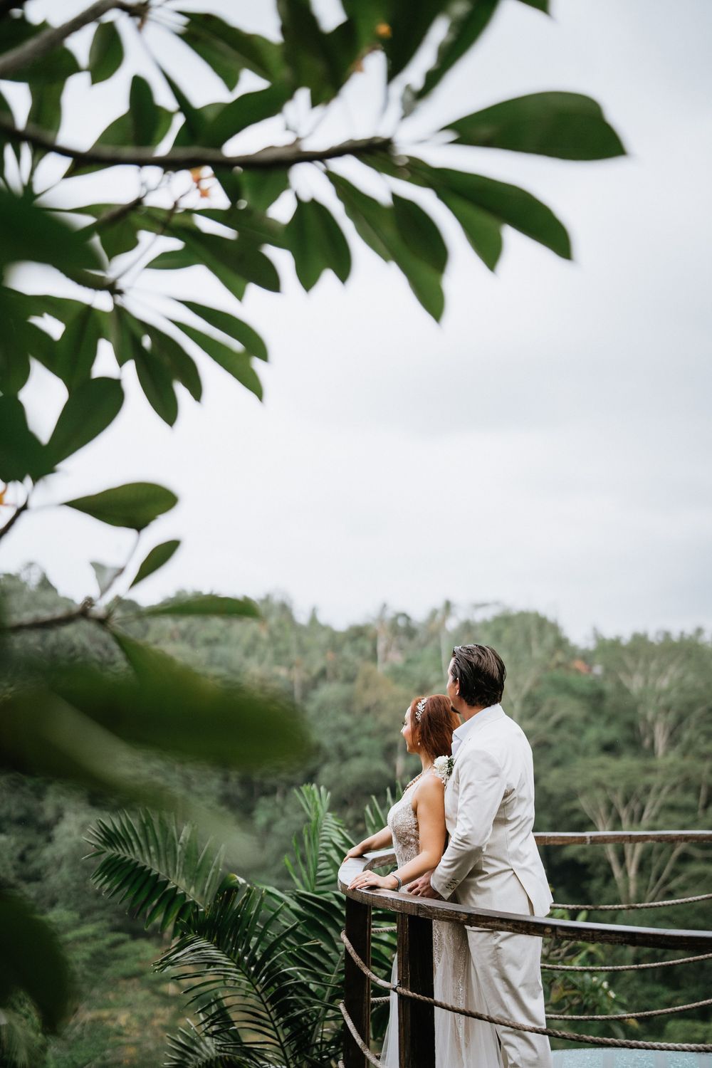 Couple enjoying scenic view from tropical overlook with lush foliage.