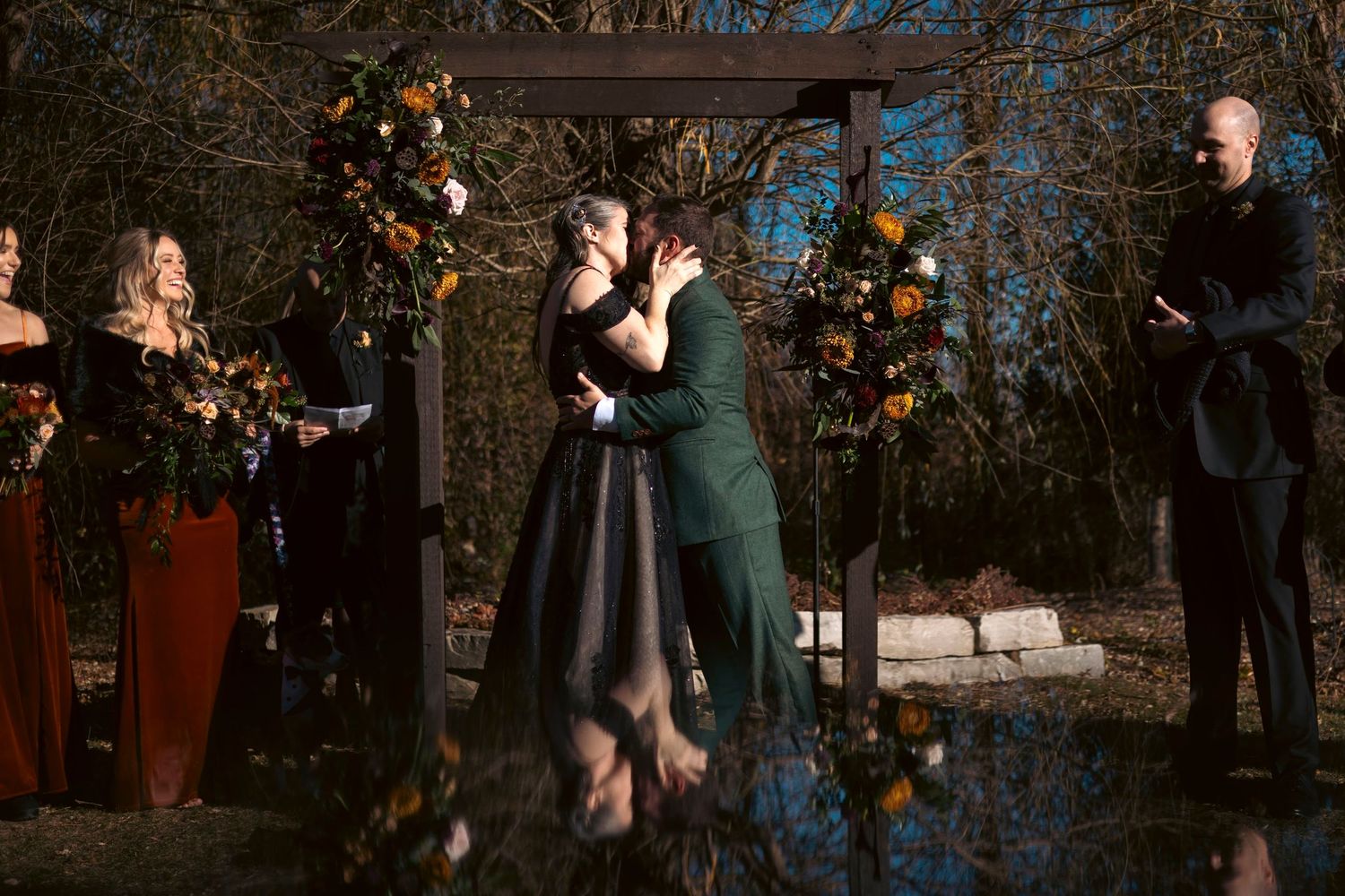 A couple performs an elegant dance move in formal attire at an evening event with onlookers in the background.