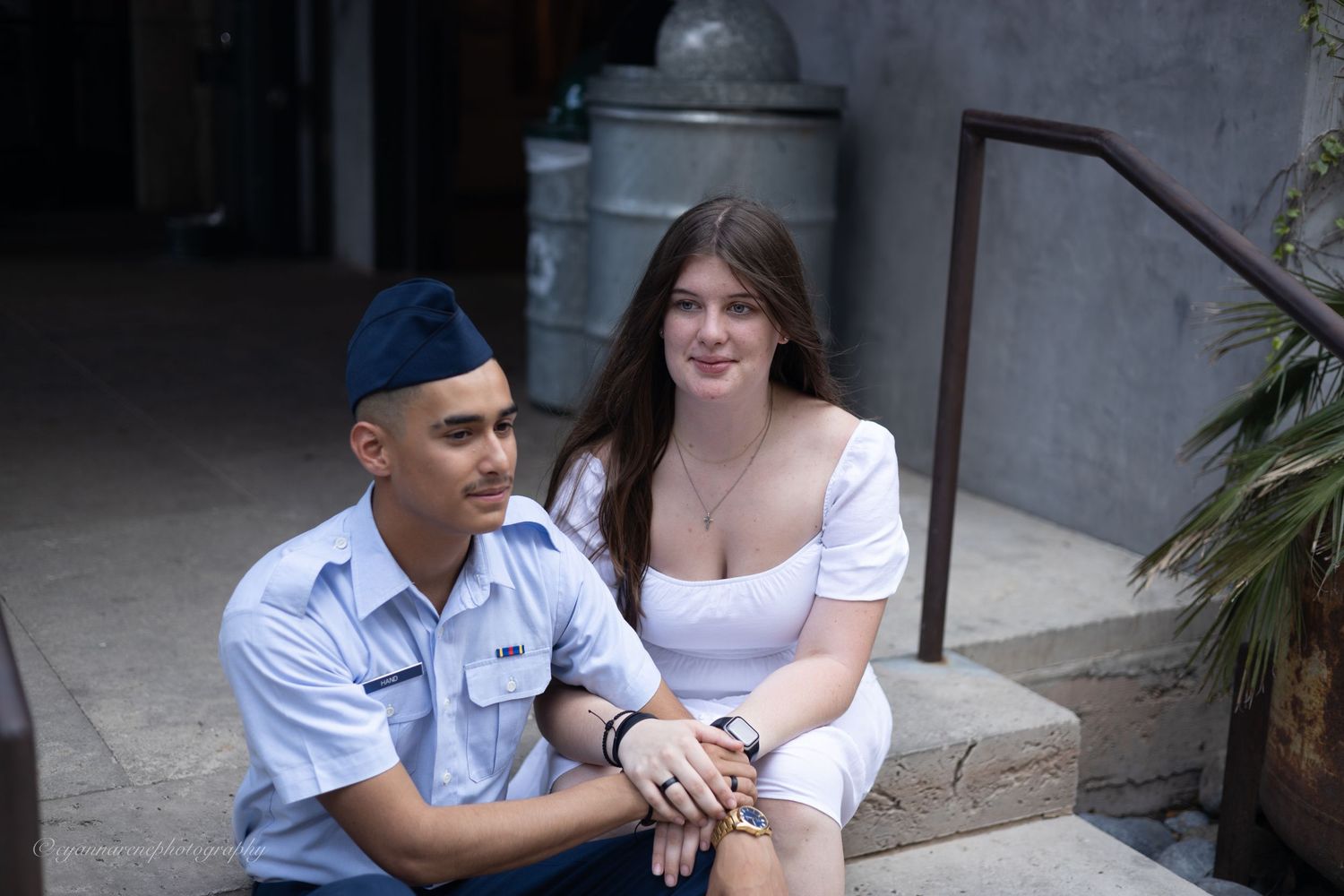 Person in a white uniform greets and interacts with another individual in an outdoor setting.