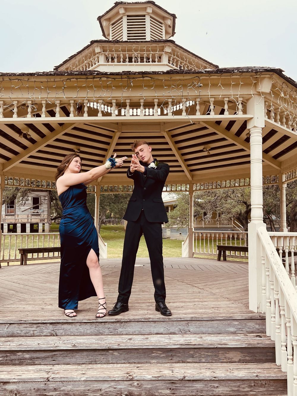 A sequence of dance poses shows two figures performing expressive movements on a wooden stage in an outdoor pavilion.