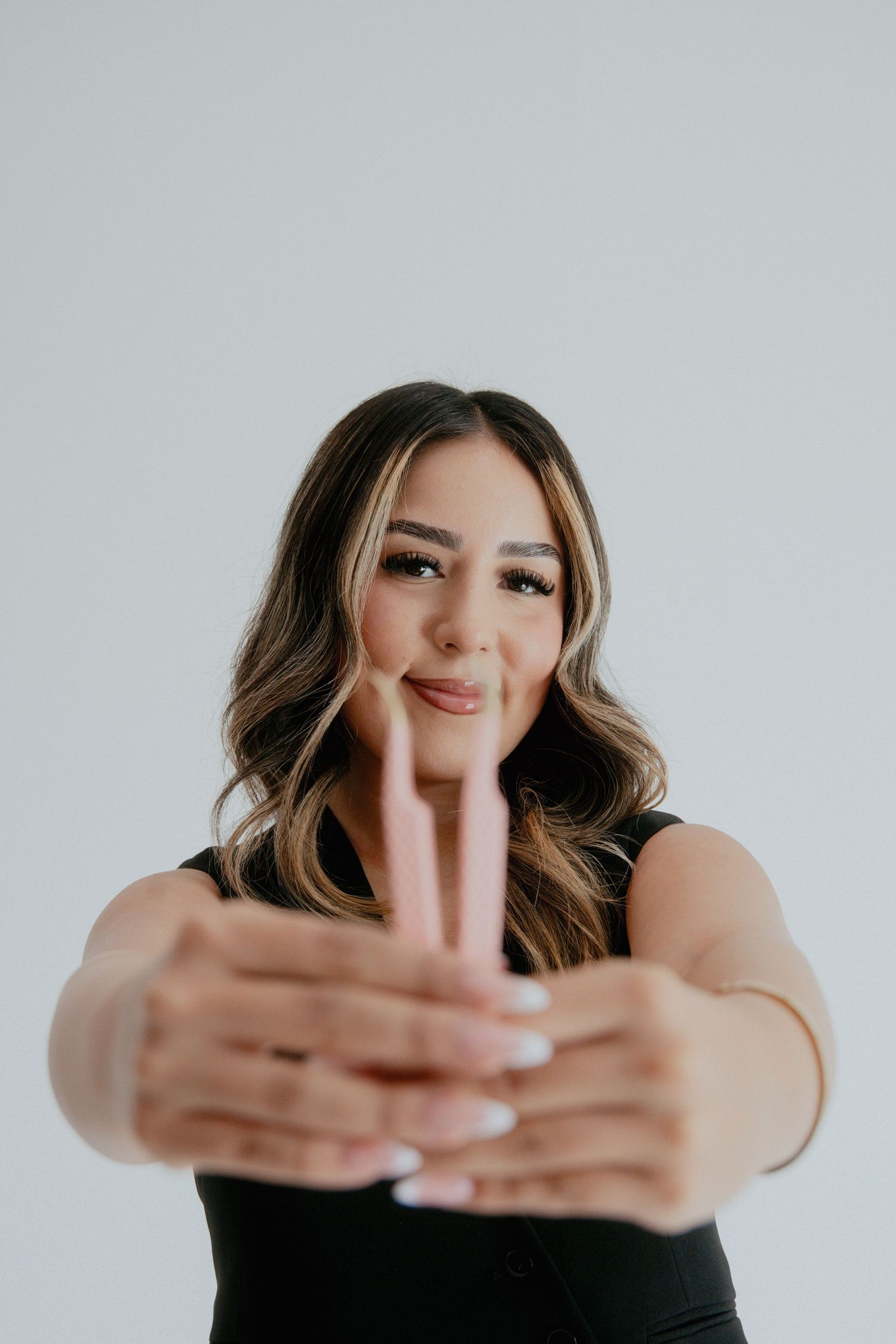 Portrait series showing playful hand gestures and movement against a white studio backdrop.