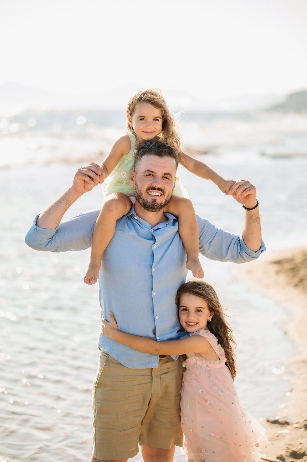 A joyful family moment at the beach with playful poses against the ocean backdrop.