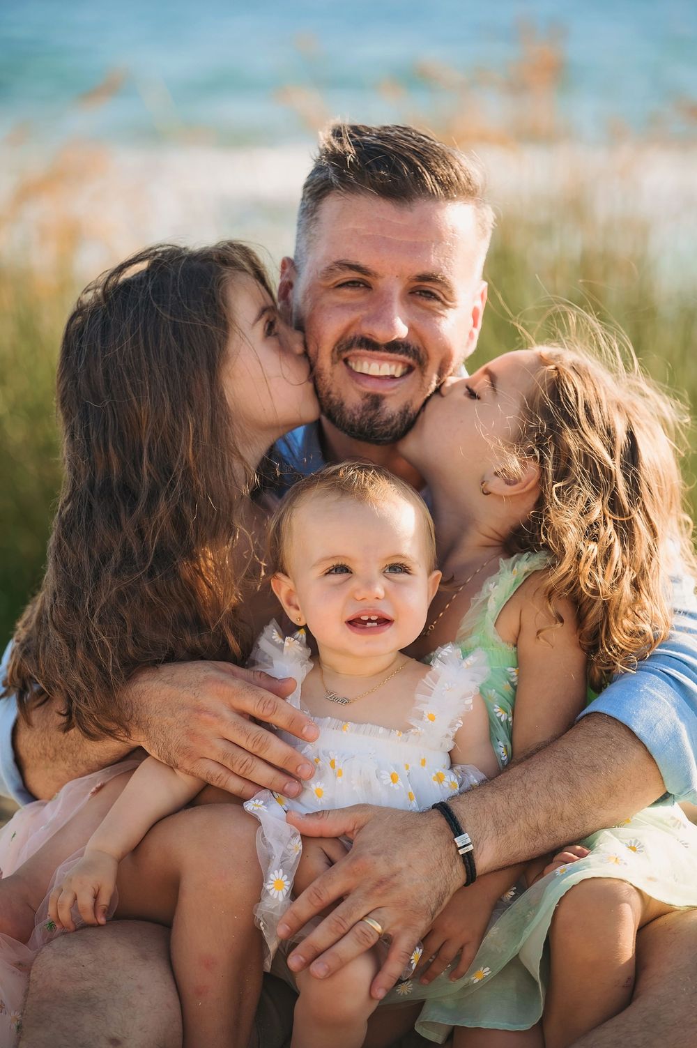 A heartwarming family portrait captured on the beach during golden hour.
