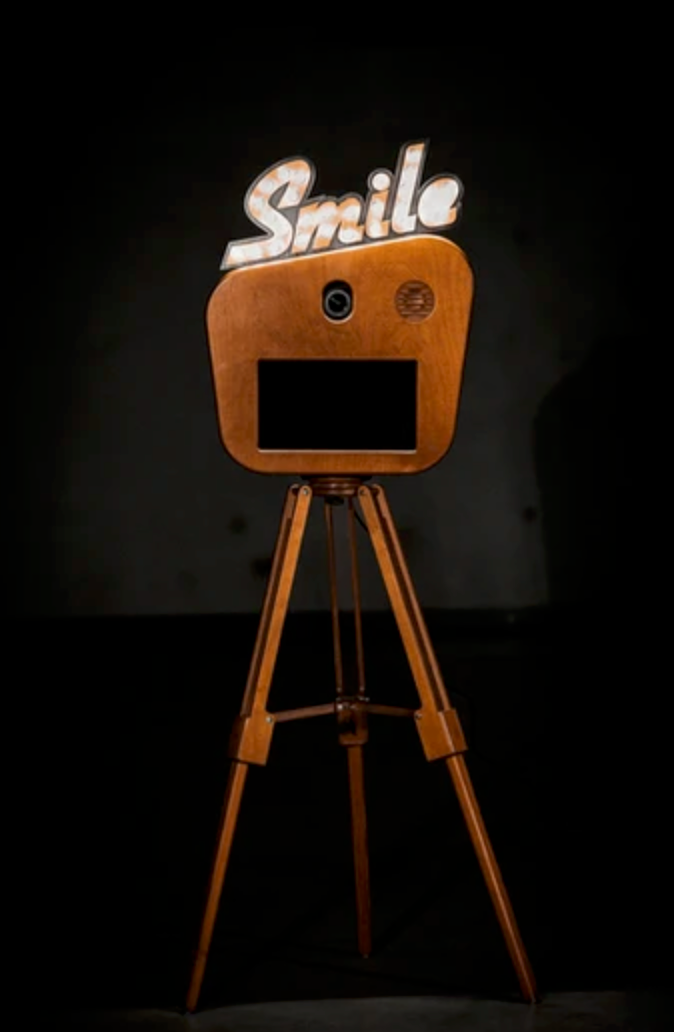 Smiling wooden robot design with curved legs and minimalist features against black background.