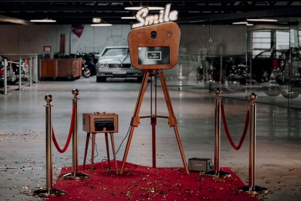 A series of posts connected by red velvet ropes leads down an empty hallway.