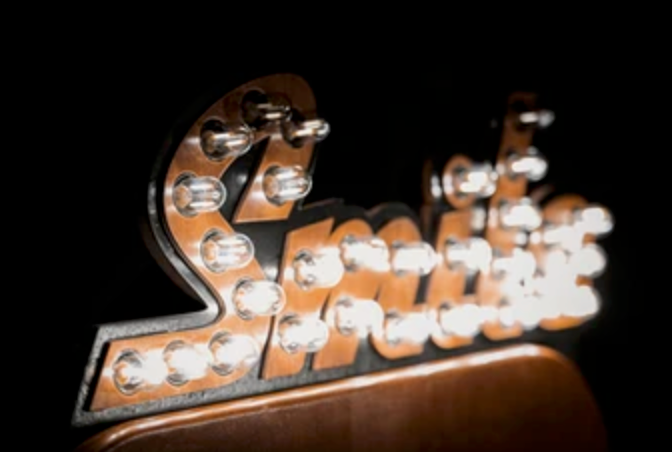 Crystal clear track lighting mounted on ceiling displays a series of evenly spaced bulbs in decorative fixtures.