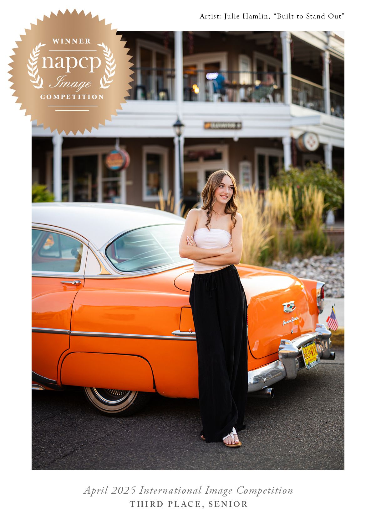 A woman in a black outfit stands beside a vintage orange car during a photography competition photoshoot.