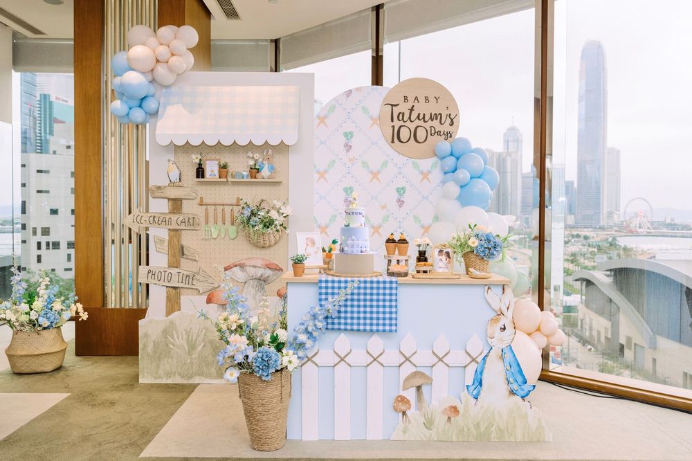 Pastel blue and white themed baby shower party setup with city views, floral arrangements, and soft decorative elements.