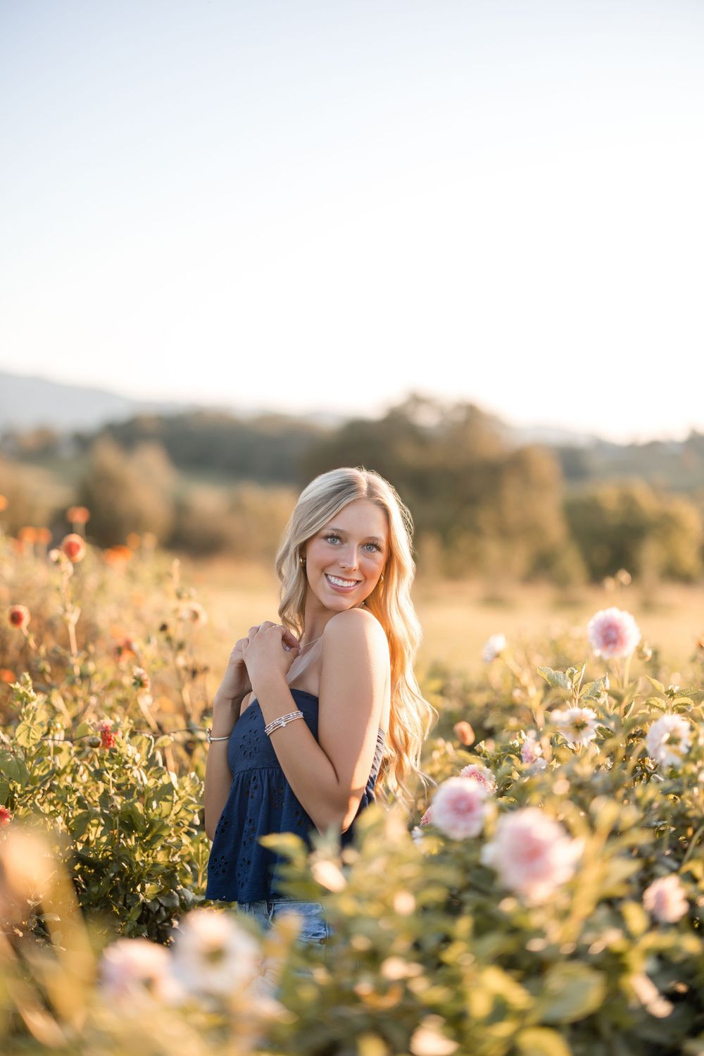 A dreamy sunset photo in a wildflower field with pink and white blooms during golden hour.