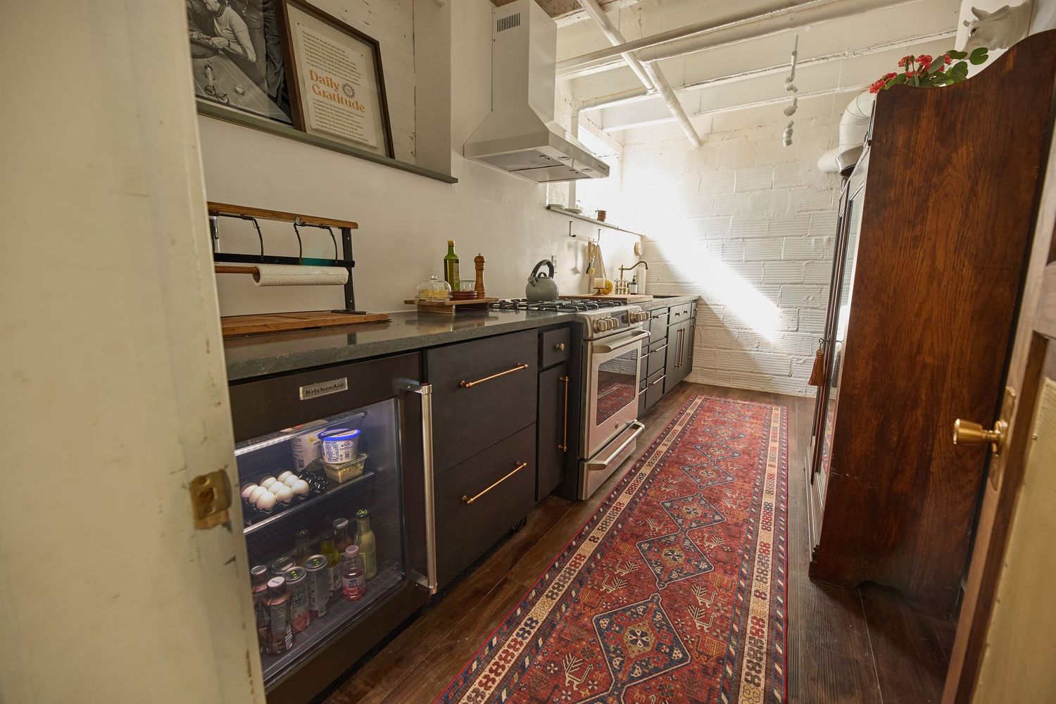 Basement hallway with wooden doors and decorative runner rug extending into the distance.