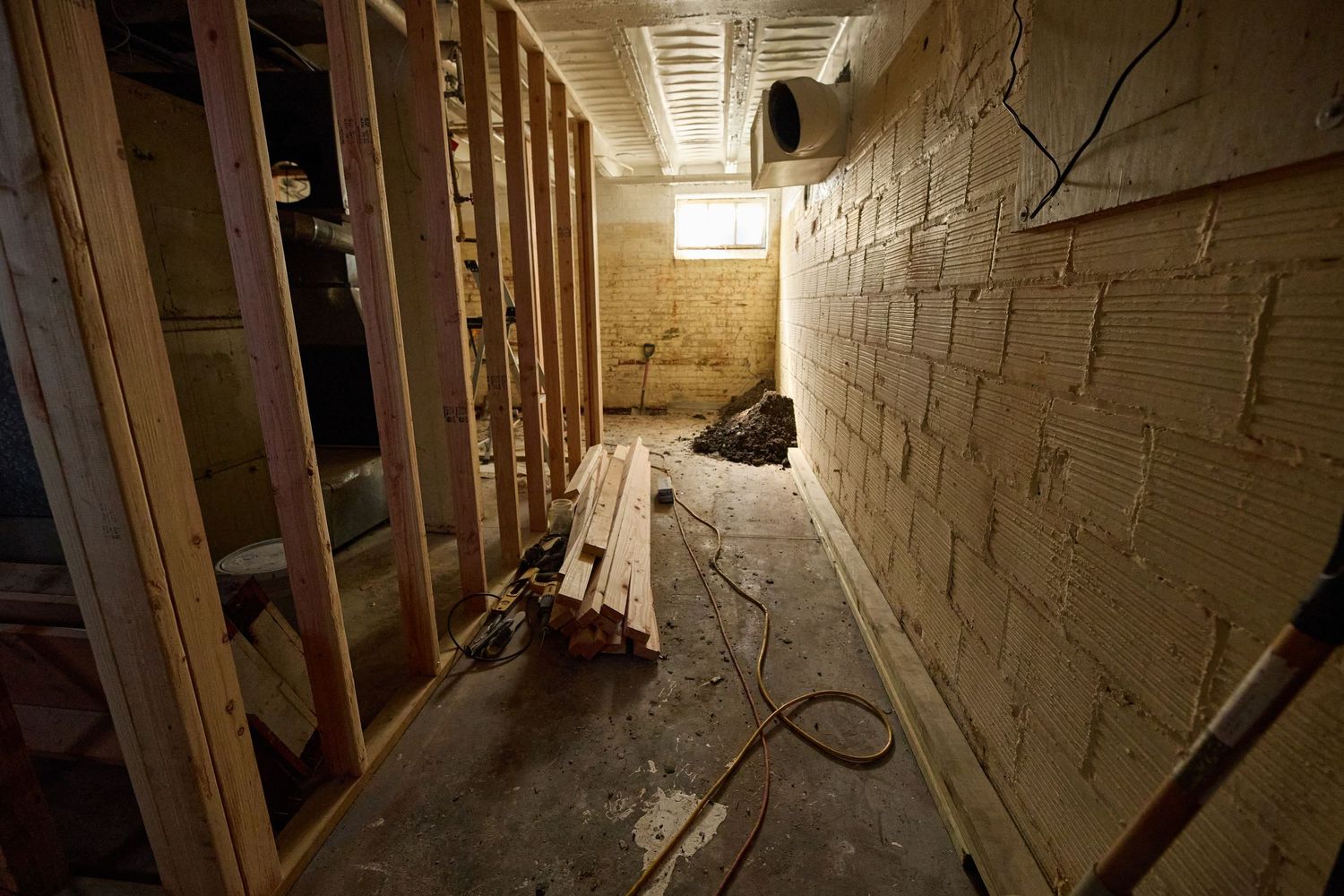 Dark basement hallway with exposed brick walls and dim lighting creating an eerie atmosphere.