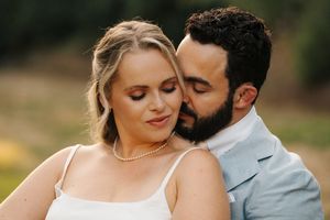 A romantic couple in wedding attire shares intimate moments during an outdoor photo session.