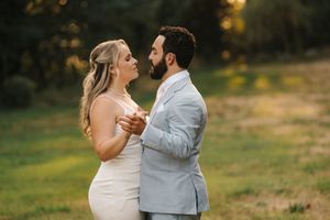 Pair enjoying an intimate dance outdoors in golden evening light with nature surrounding them.