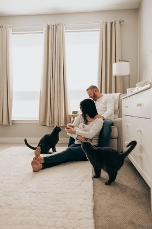 A playful sequence of images showing someone relaxing on a carpeted floor with their black cat at home.