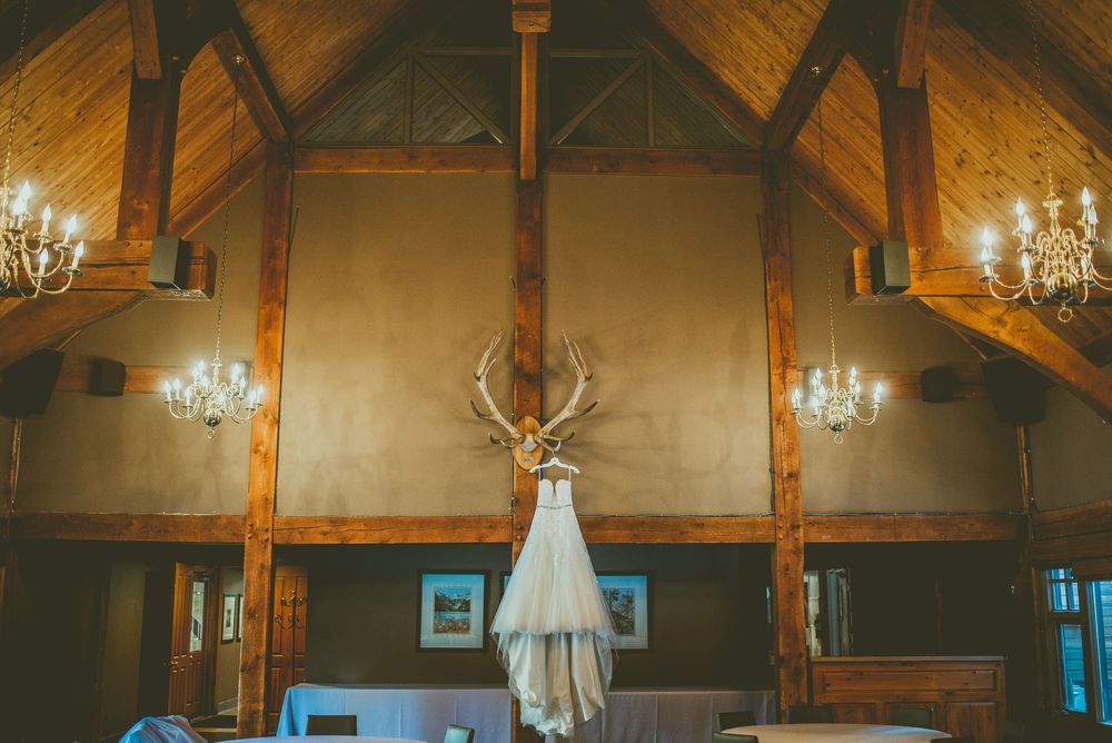 A rustic wooden lodge interior with exposed beams, chandeliers, and elegant decor. Banff Micro Wedding Photographer