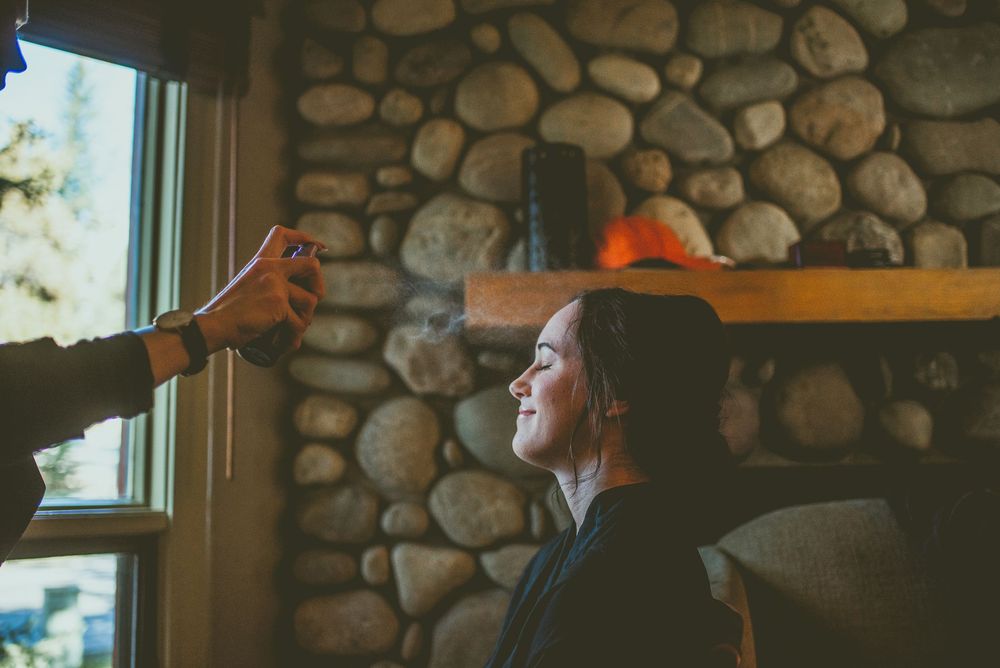 Bride sits in a casual restaurant with rustic stone walls and large windows letting in natural light. Banff Micro Wedding Photographer