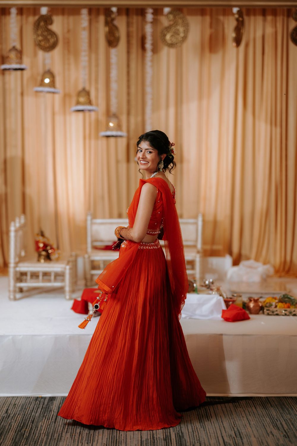Beautiful wedding ceremony setup with warm lighting and decorative elements at an indoor venue featuring red accents.