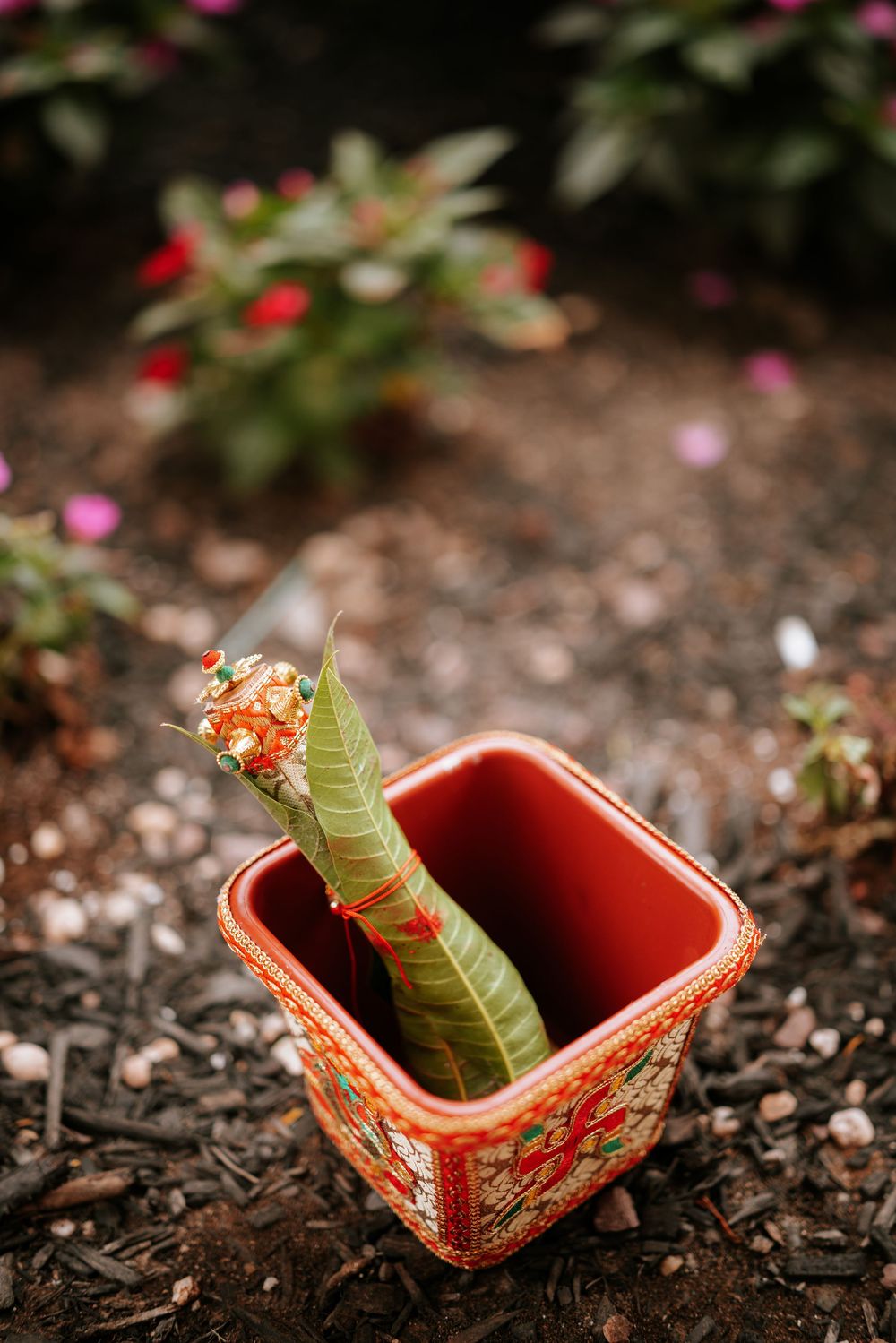 Sequential images show an orange and red ceramic pot resting among fallen leaves while a green leaf gently falls into it.