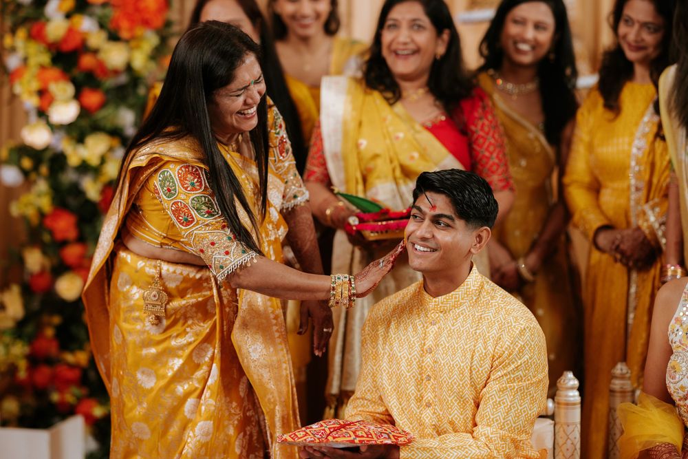People in vibrant yellow traditional Indian attire celebrate during what appears to be a wedding ceremony or cultural event.