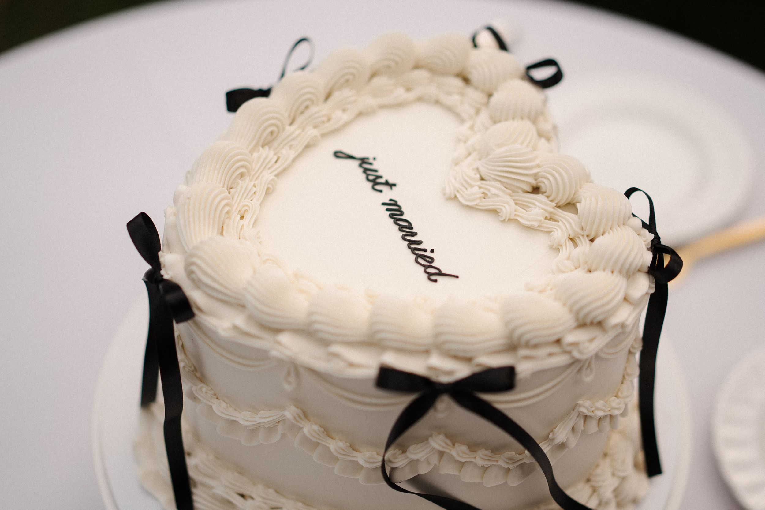 Elegant white round floor cushions with black ribbon accents arranged in a row.