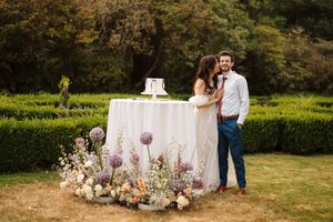 Romantic outdoor engagement session with blush toned floral altar setup in a serene garden setting.