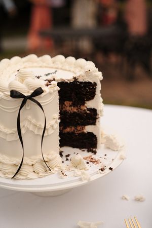 A sequence of images showing a white frosted chocolate cake being sliced and served on plates with black ribbon decor.