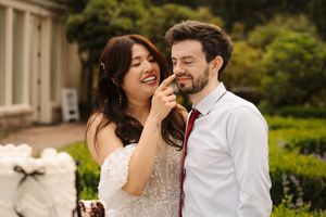 A couple shares joyful laughter while seated at an elegantly decorated outdoor table.