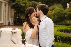 A happy couple shares a joyful moment together in an outdoor garden setting.