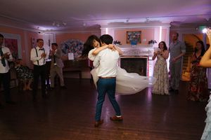 Couples dancing together on a dimly lit dance floor during a formal evening event.