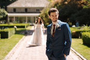 People celebrate a sunny outdoor wedding in a lush garden setting with elegant casual attire.