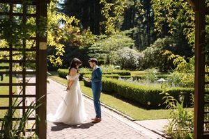 A couple shares an intimate moment in a lush garden setting with beautiful natural lighting and greenery.