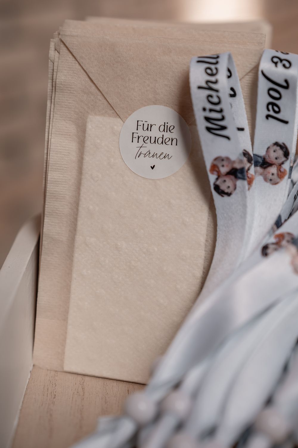 Close-up detail shot of wedding seating cards arranged on a light wooden surface with selective focus.