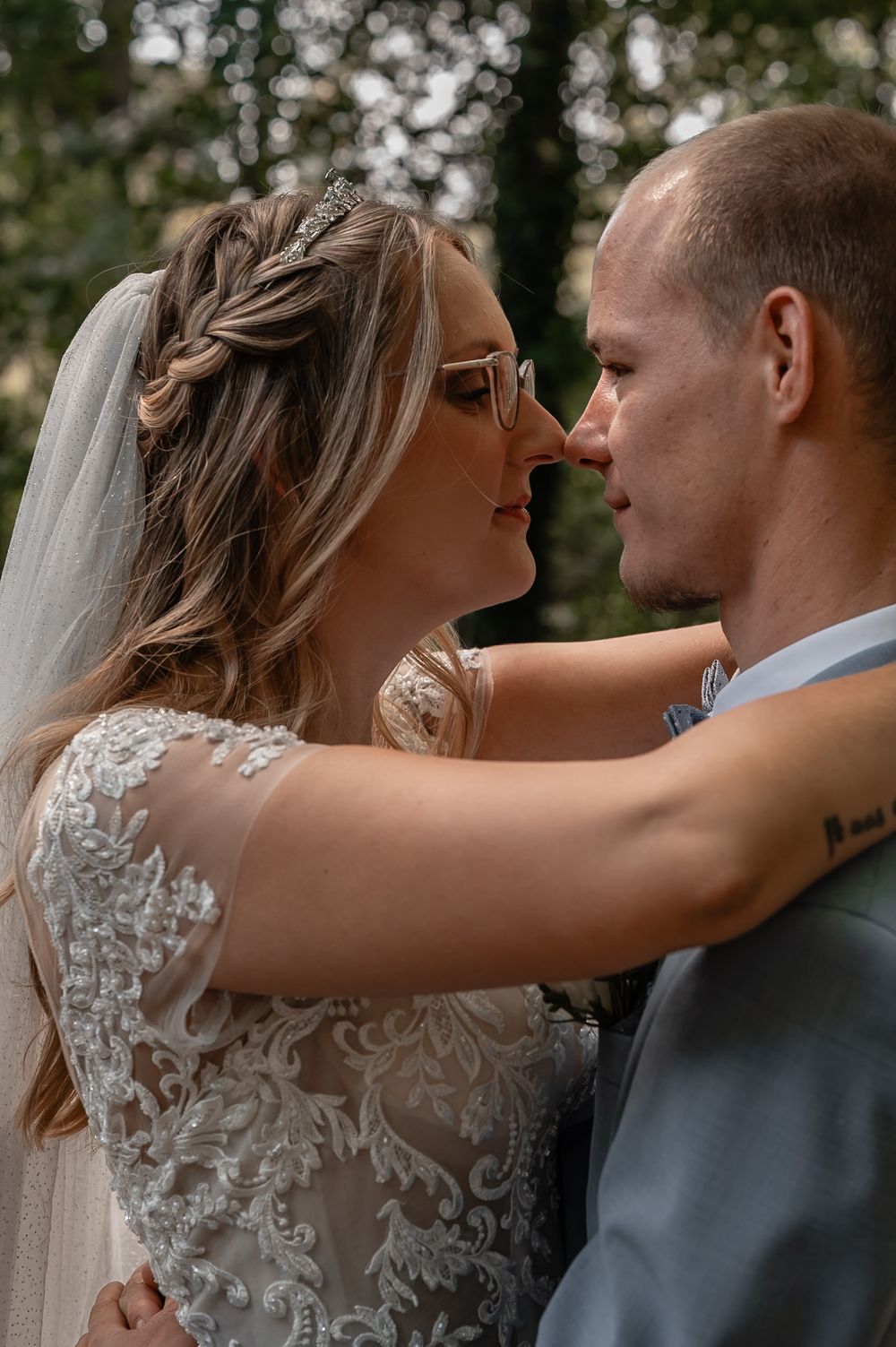 Close-up sequence of a tender wedding moment showing the bride's lace dress details and flowing veil.