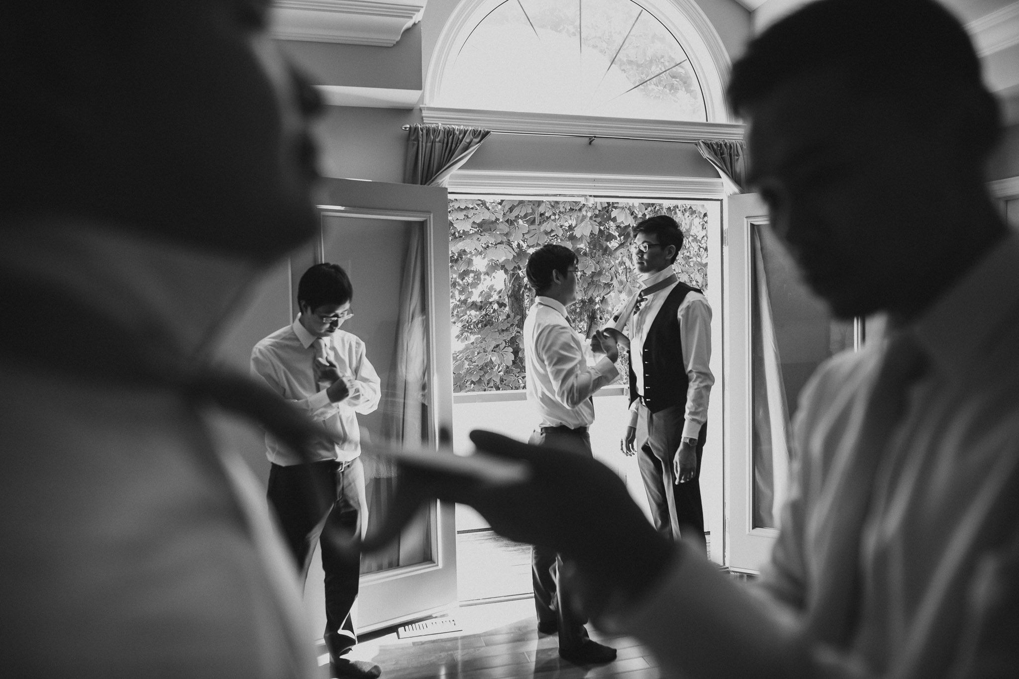 Black and white candid shots of people dancing and celebrating at an indoor event.
