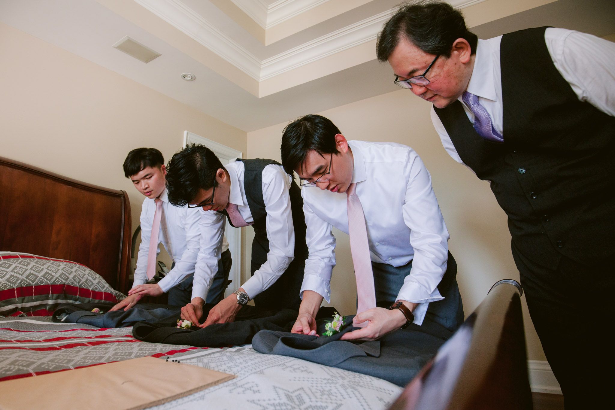 People in formal attire gather around a table signing documents during a ceremony.