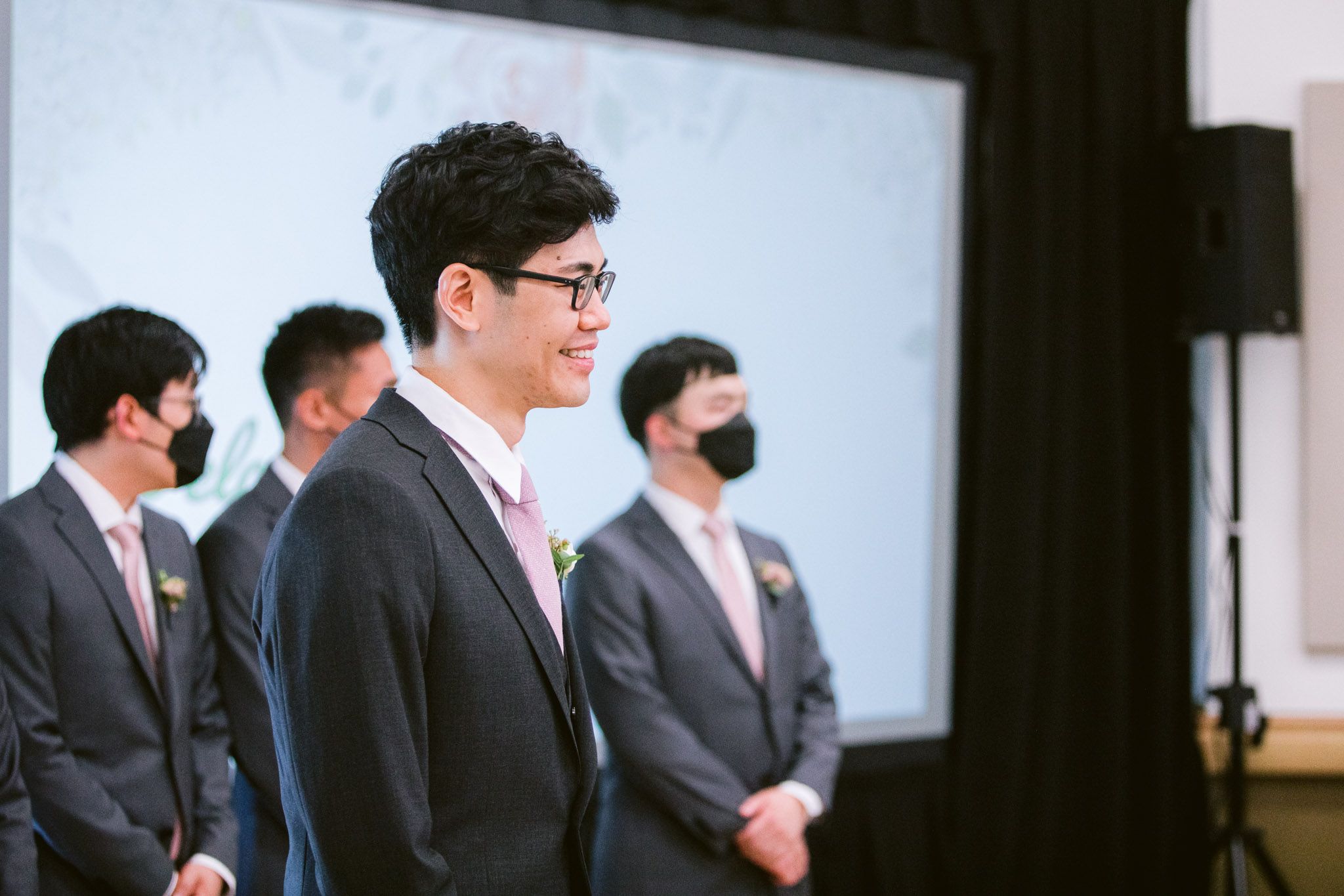 Row of formally dressed guests seated at a wedding ceremony.