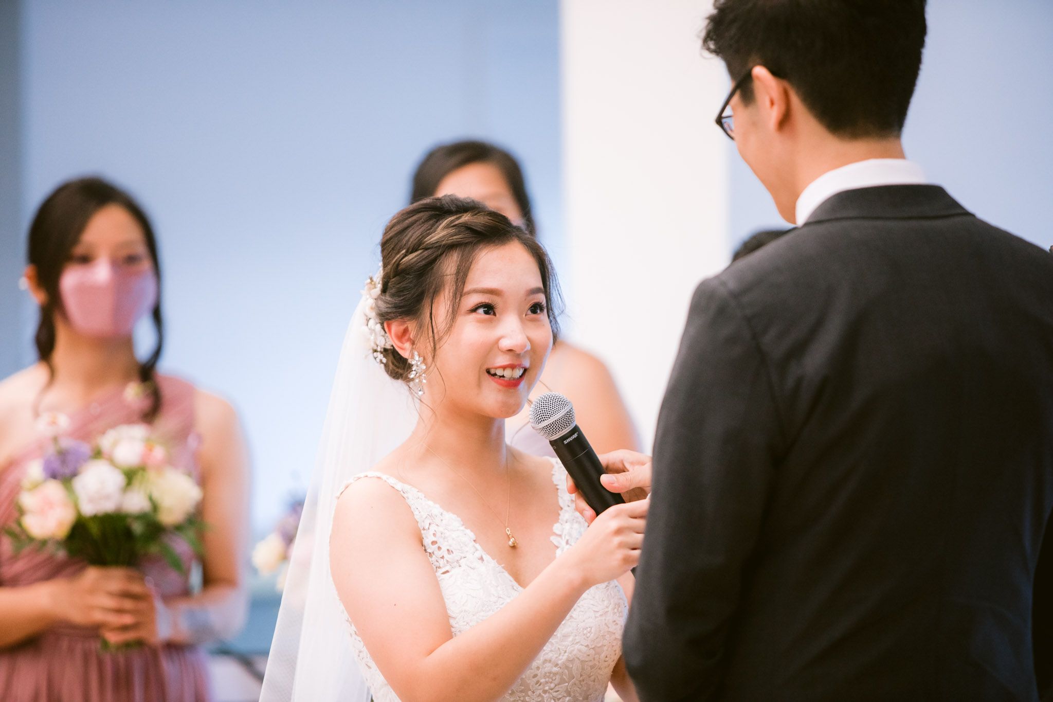 Wedding celebration in a bright indoor venue with guests enjoying speeches.