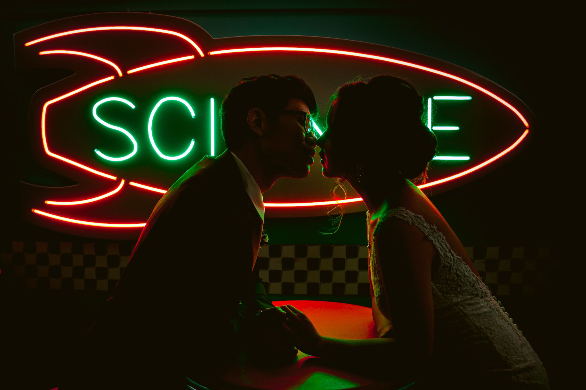 Colorful neon signs illuminate a dark venue space creating a modern ambiance.