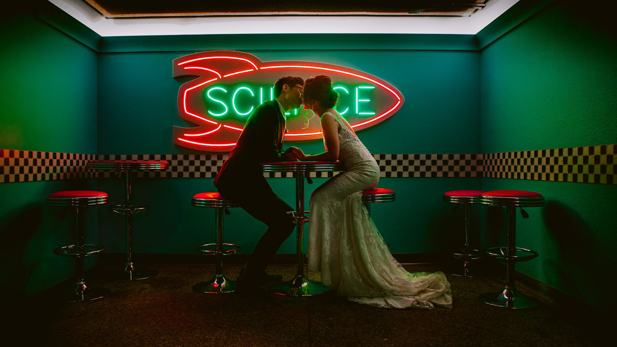 Event space with green ambient lighting and illuminated signage.
