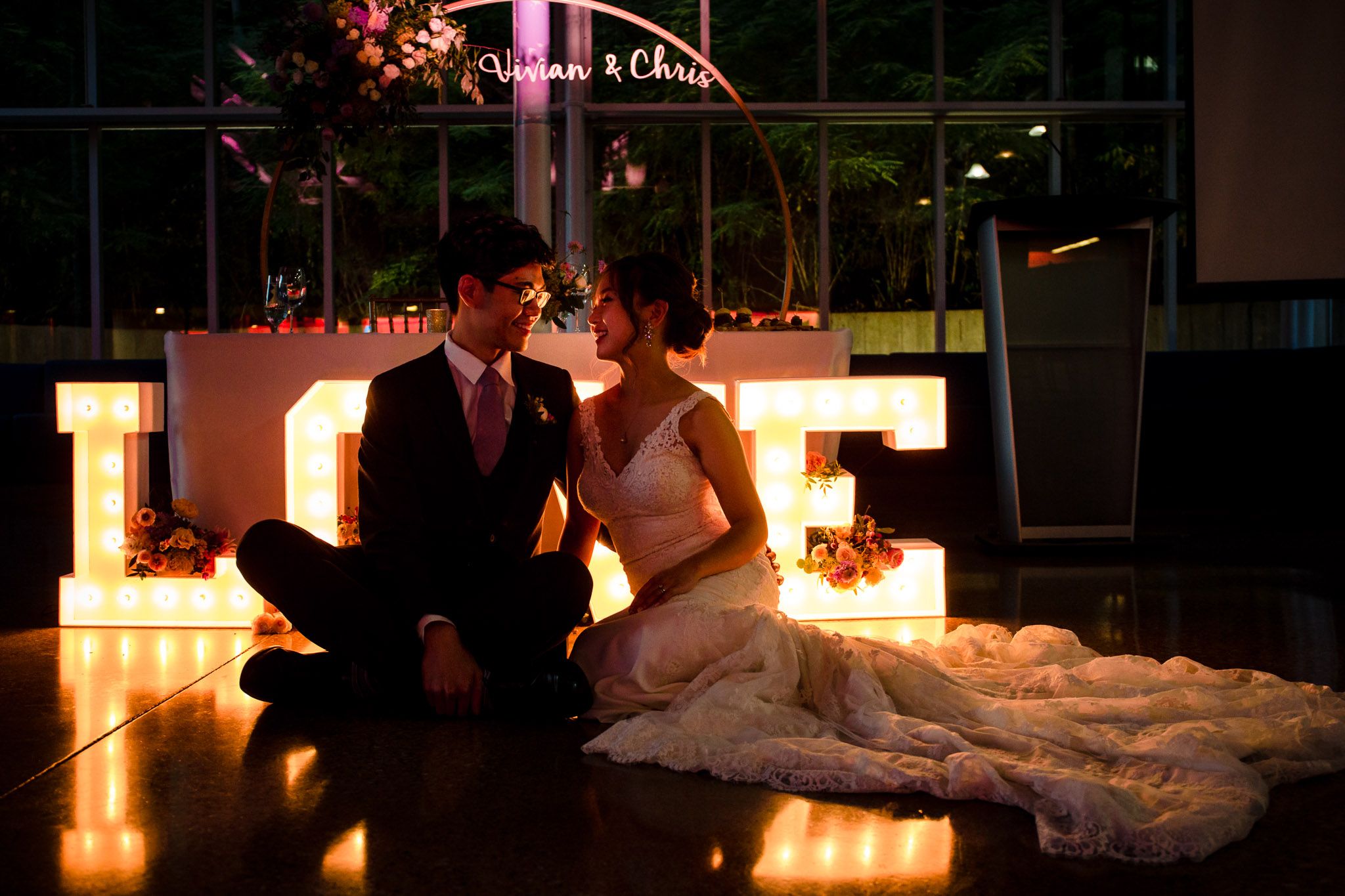 Romantic evening reception with soft lighting and glowing LOVE letters.