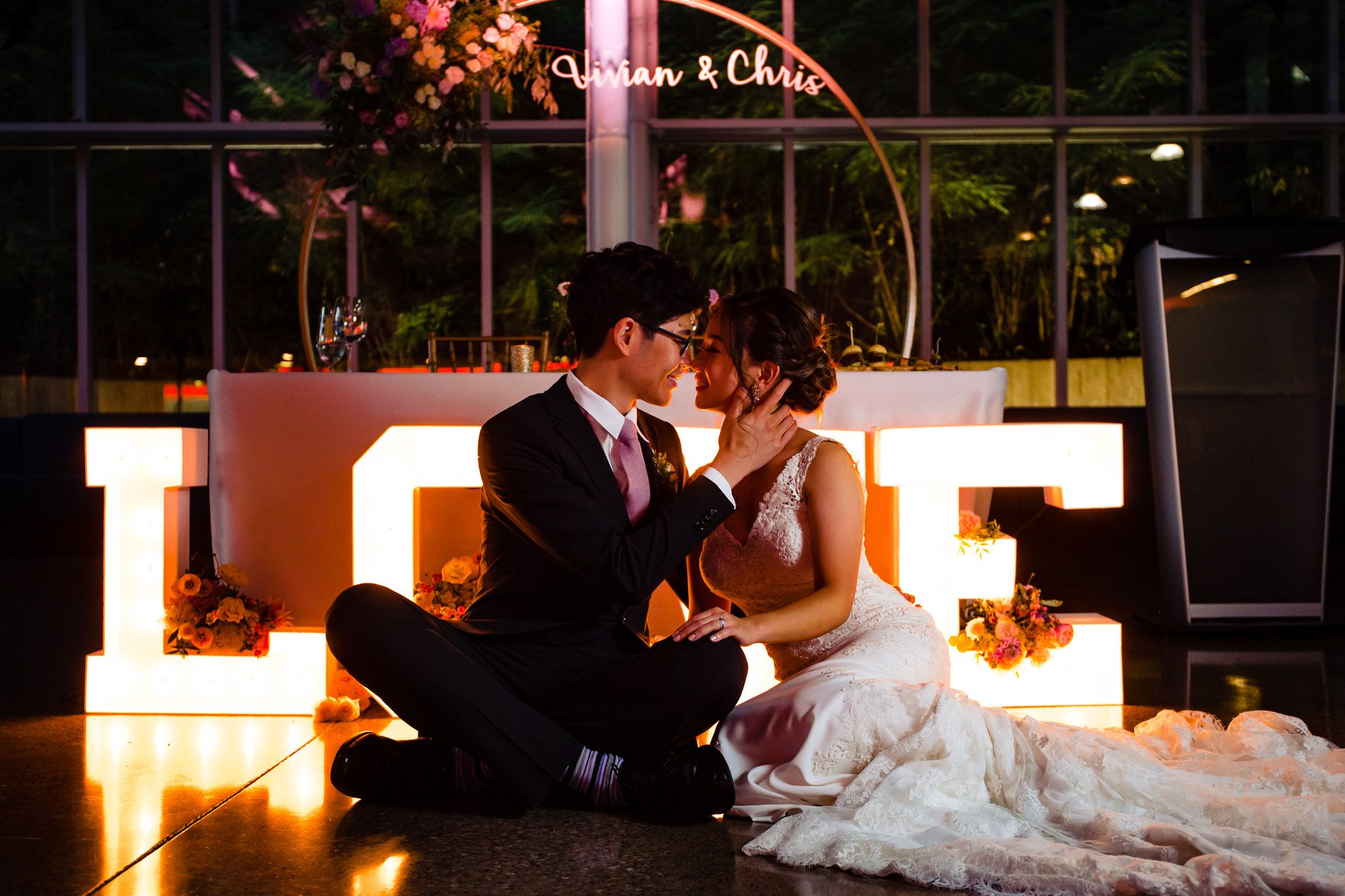 Wedding reception venue with warm ambient lighting and elegant table settings at dusk.