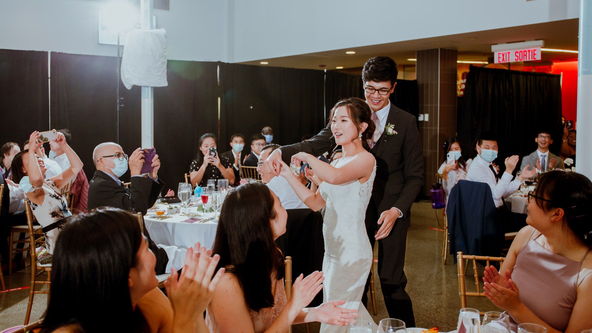 Wedding reception guests enjoying entertainment and celebrations indoors.