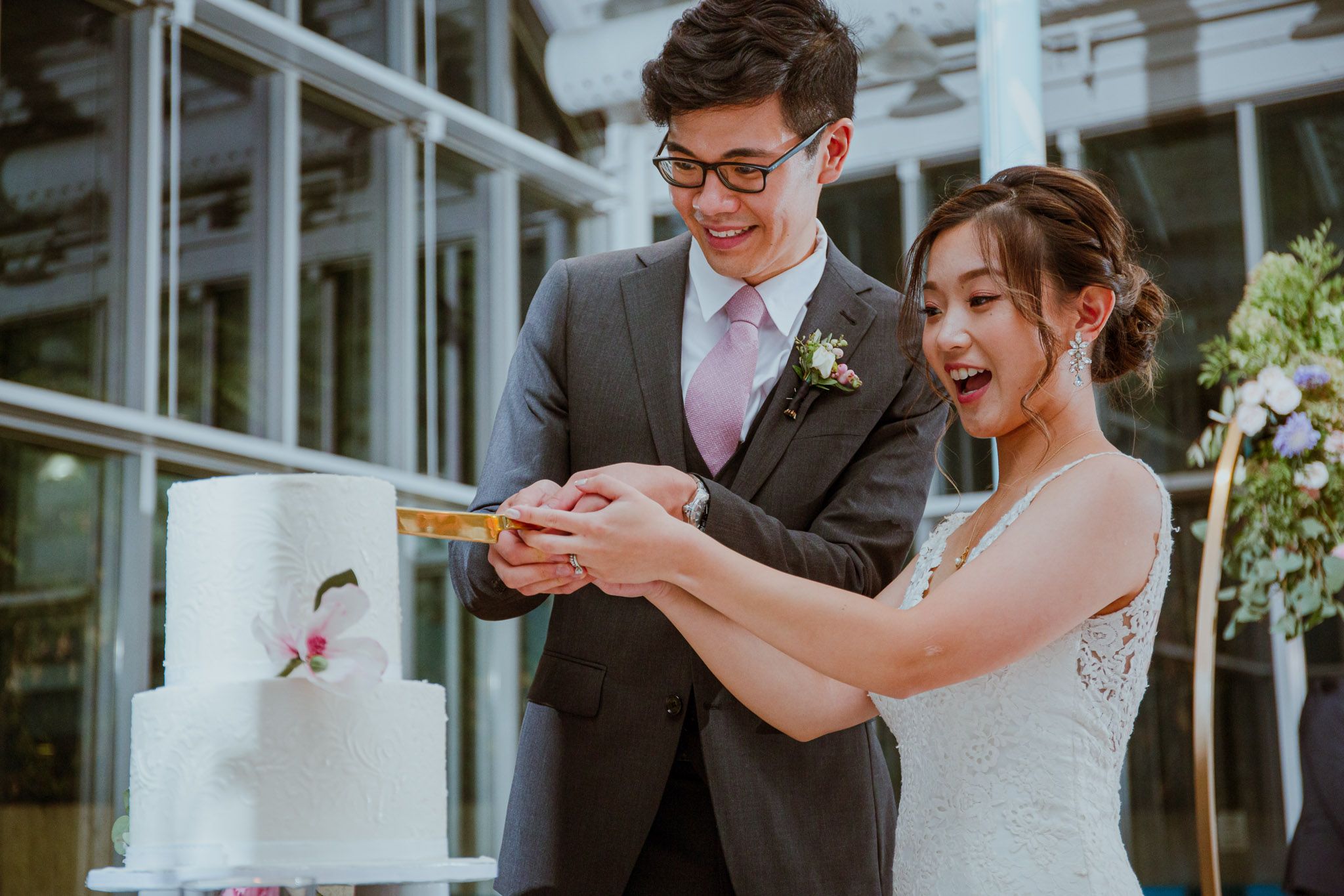 Couple sharing a playful moment while taking photos in a bright indoor space.