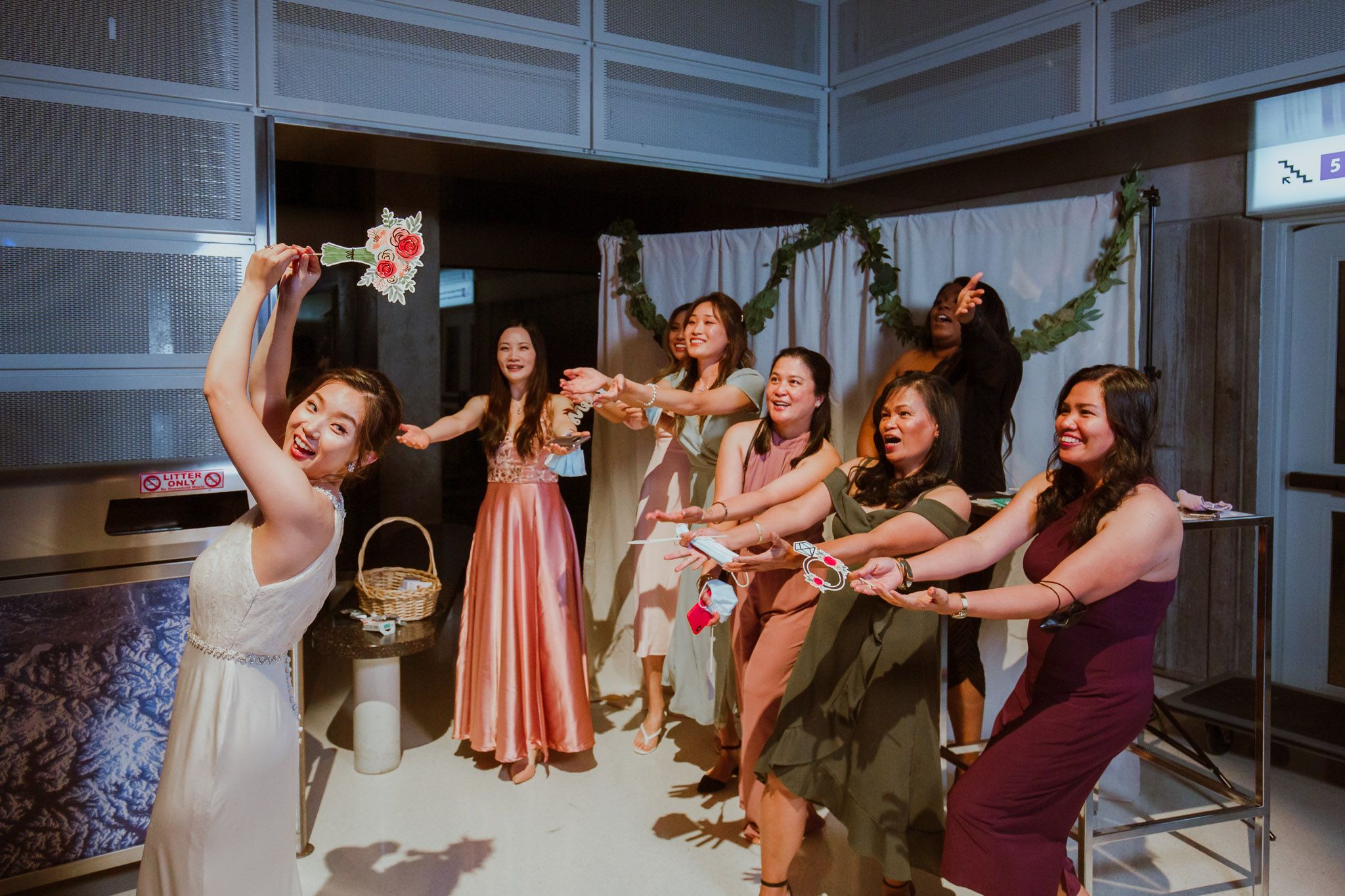 A group celebrates joyfully with raised glasses and drinks during a festive gathering in an indoor setting.