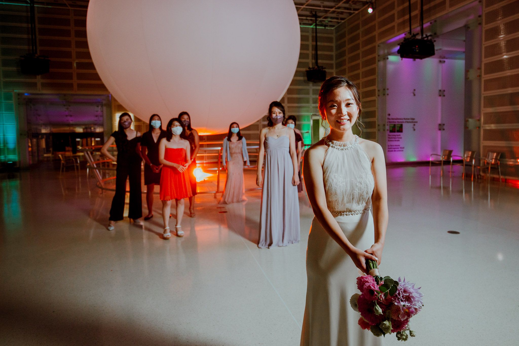 Modern event space with brick walls and colorful lighting during a celebration.